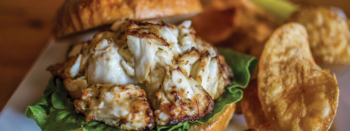 crabcake with lettuce on a roll on a plate.